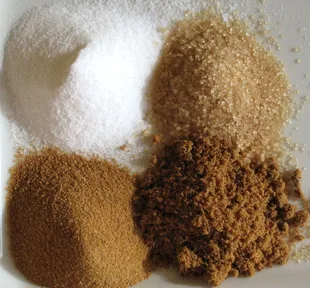Four kinds of sugar, from white crystals to dark unrefined cane sugar