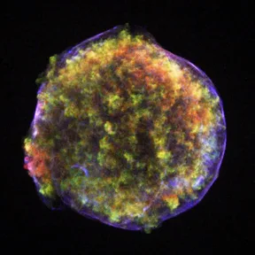 The remains of Tycho’s supernova: a glowing round shell of gas in many colors, seen in X-rays